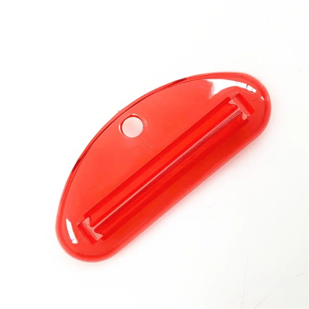 Red toothpaste tube squeezer dispenser with slotted metal insert and side hanging hole