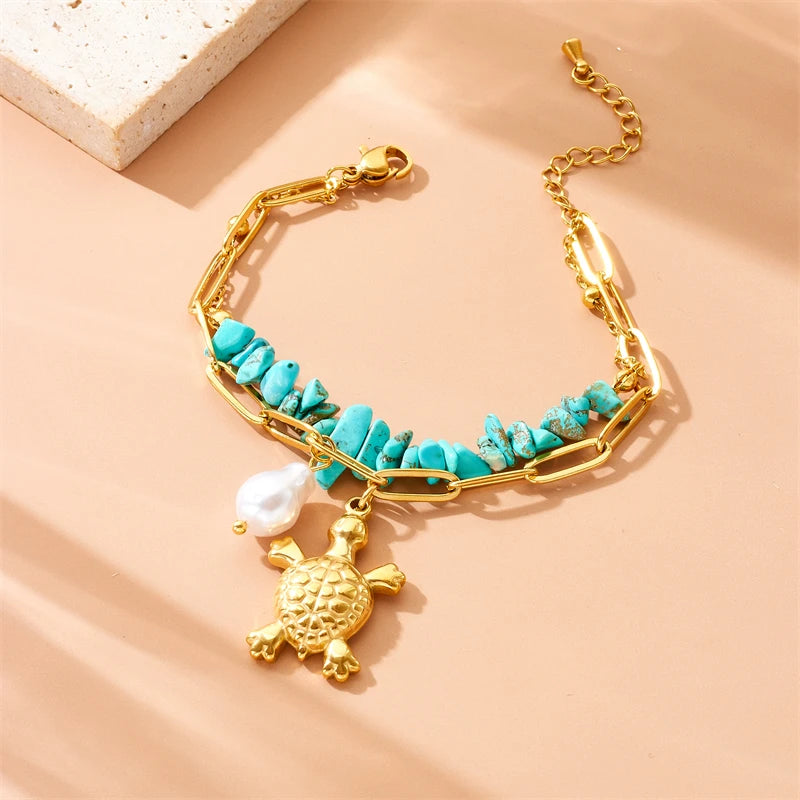 Turquoise beaded double-layer necklace with gold turtle charm and pearl drop, on base