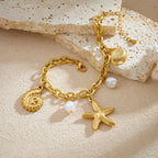 Gold-tone charm necklace with seashell, disc, starfish, and white pearl drop charms