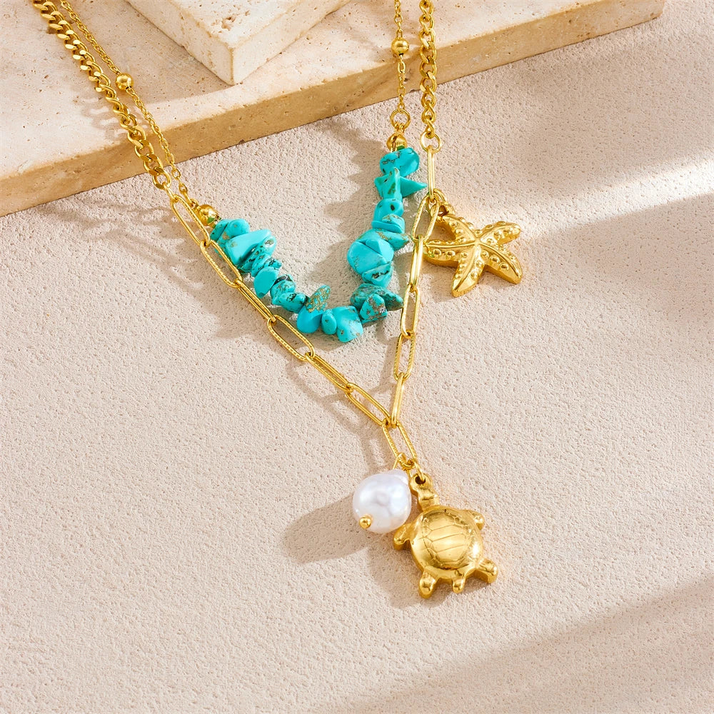 Turquoise beaded double-layer necklace with gold starfish and turtle charms, close-up