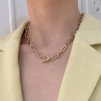 Gold-tone oval link chain collar necklace with heart clasp and small bar charm