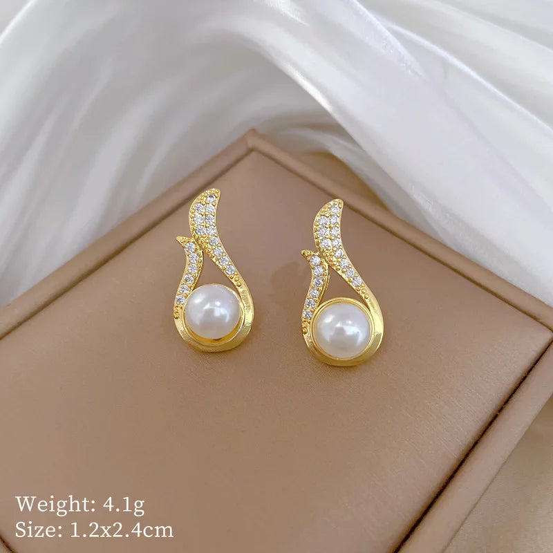 Gold-tone pearl drop stud earrings with crystal pavé accents