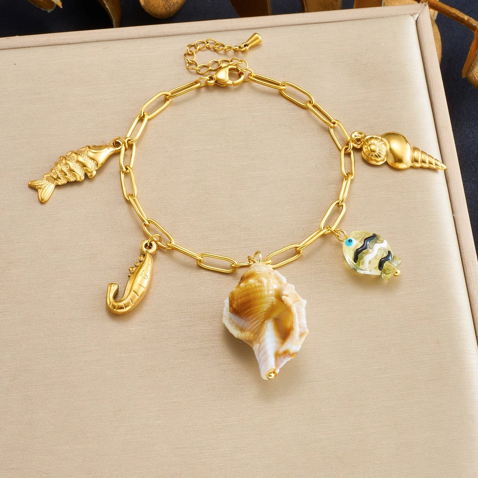 Gold-tone shell charm bracelet with fish, lobster, sea-horse, and seashell charms
