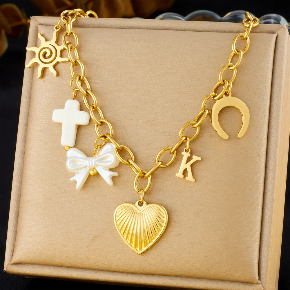 Gold-tone multi-pendant necklace with heart charm, horseshoe element, and initial K