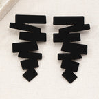 Geometric stud earrings in black with bold zigzag silhouette and flat stud backs