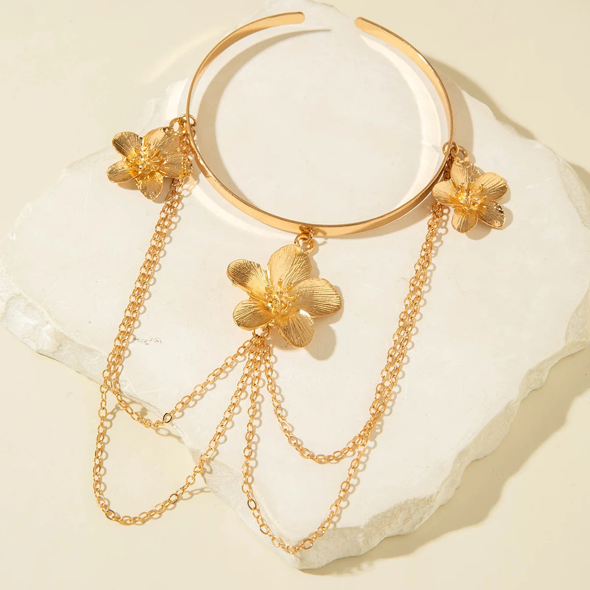 Gold flower upper arm bracelet with three dangling chain strands and flower charms