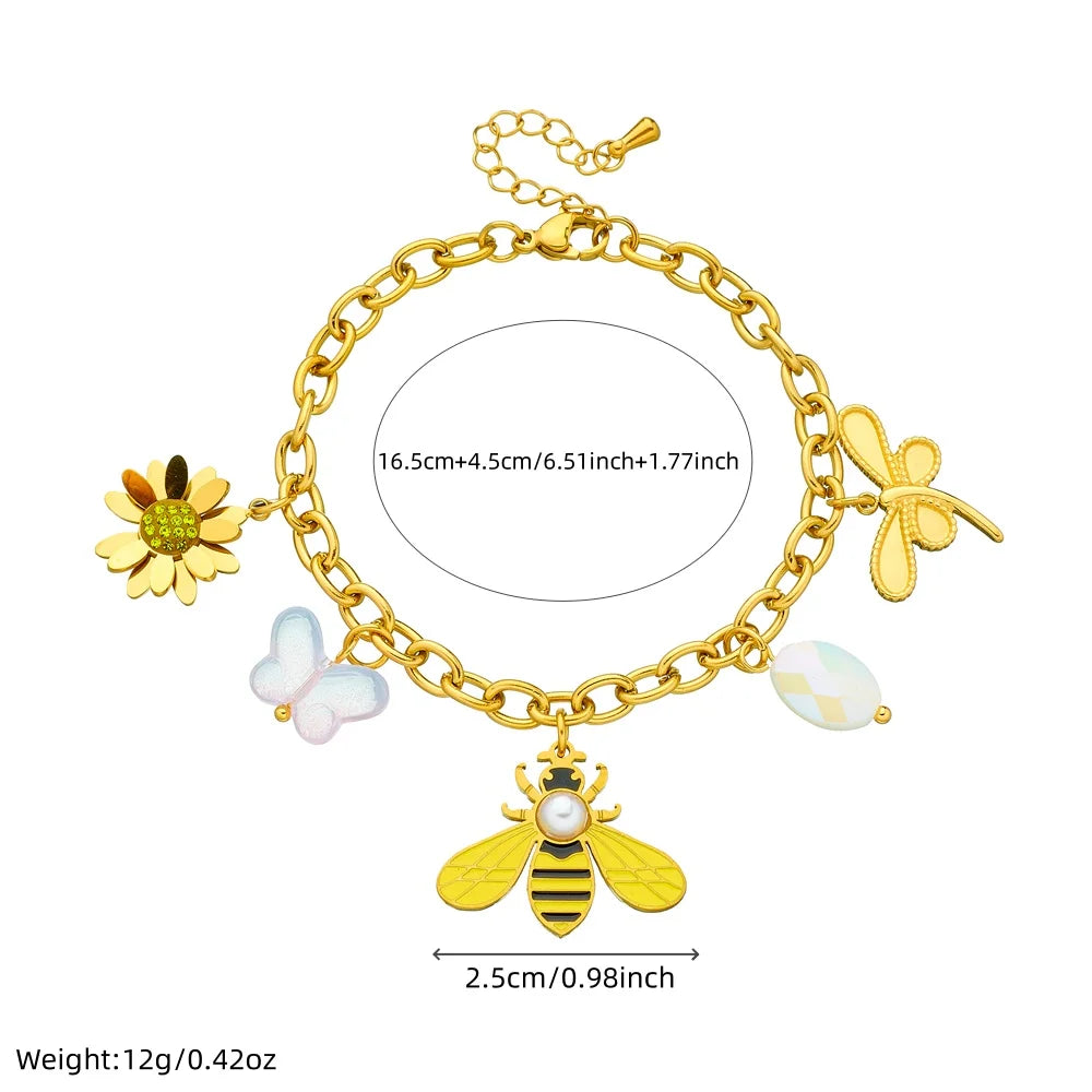 Gold-tone charm bracelet with bee centerpiece, flower dangles, and pearl accents