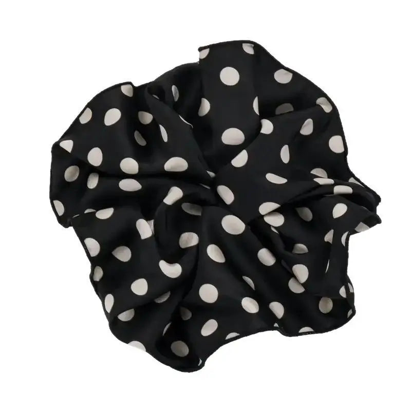 Black cotton polka-dot scrunchie with white dots, gathered fabric bow shape