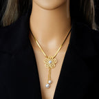 Gold-tone flower necklace with white pearl drop on a fine chain