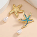 Gold-tone starfish pendant earrings with blue/turquoise crystals and white pearl drops on hooks