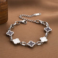 Four-leaf clover charm bracelet with silver-tone chain and white enamel clover charms