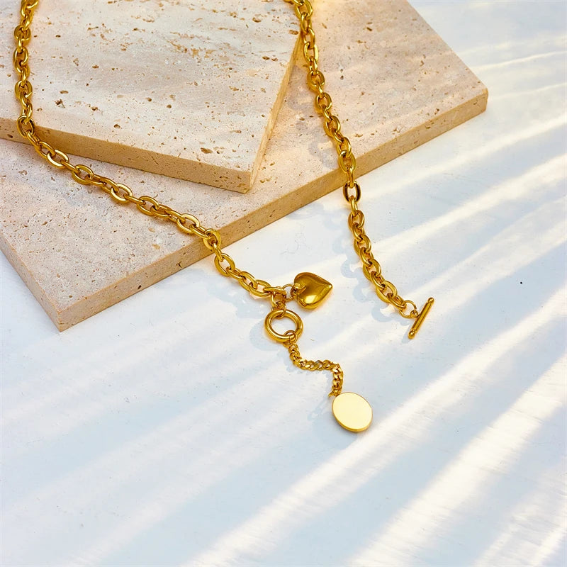 Gold-tone charm pendant necklace with small heart charm and coin disc charm