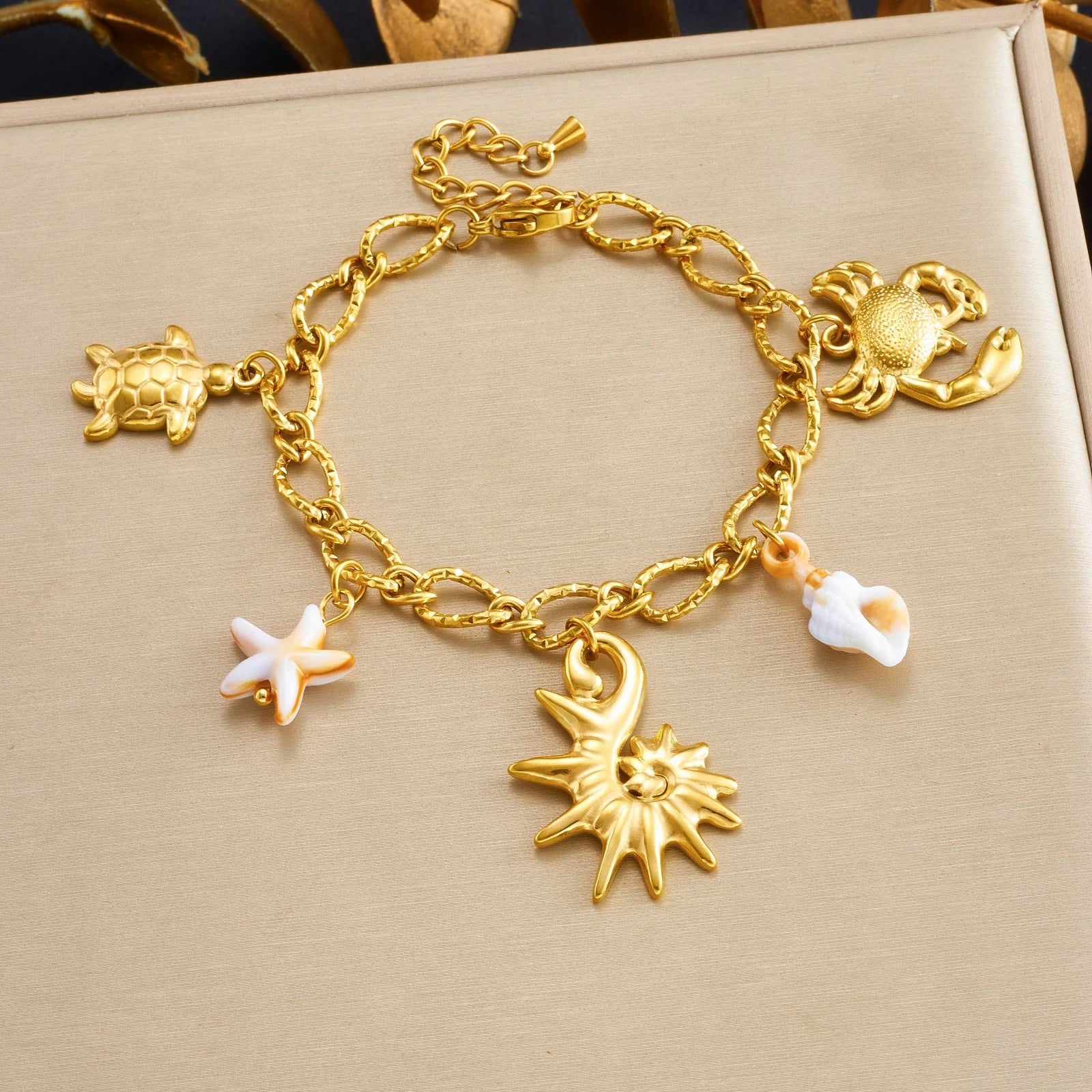 Gold-tone enamel ocean charm bracelet with turtle, octopus, sunburst and starfish shells