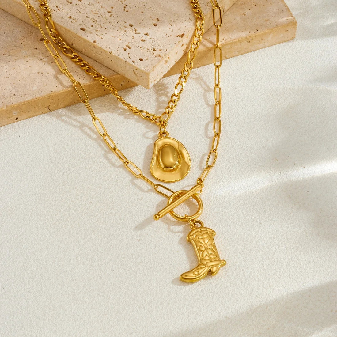 Gold-tone layered chain necklace with cowboy hat and boot charm pendants