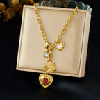 Gold tone charm necklace with red heart pendant, white pearl hearts, and flower charm