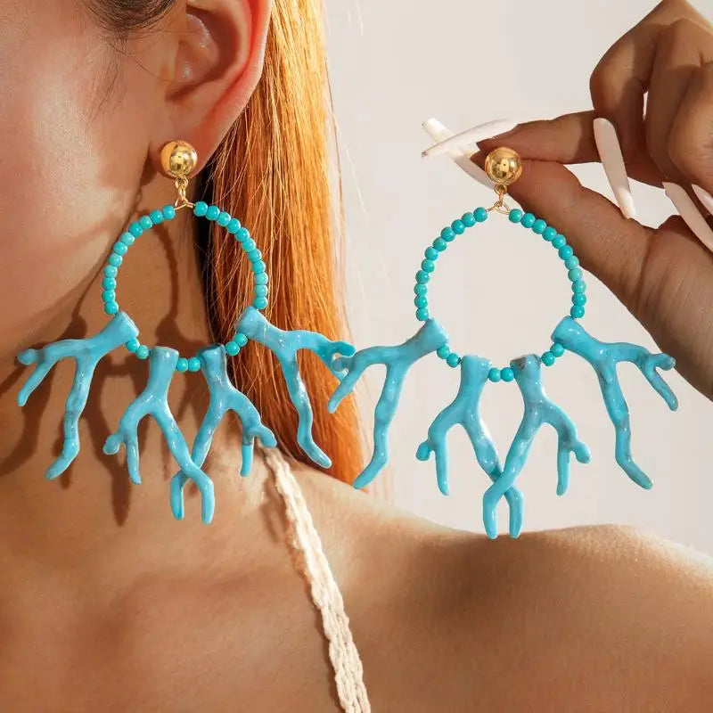 Turquoise acrylic drop earrings with beaded hoops and hanging fringe details
