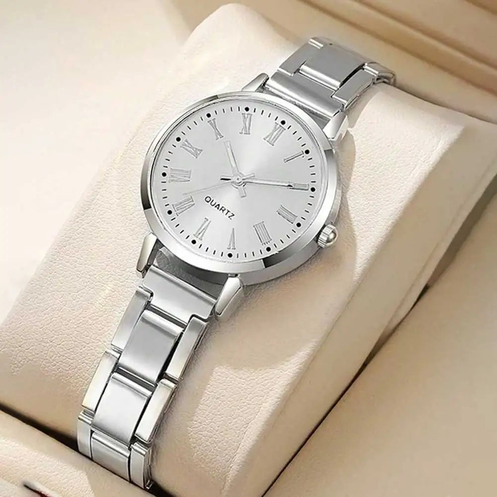 Silver-tone quartz watch with white dial and metal link bracelet on a display cushion