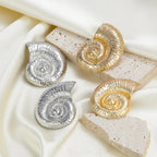 Conch shell stud earrings set in silver and gold tones with round spiral details