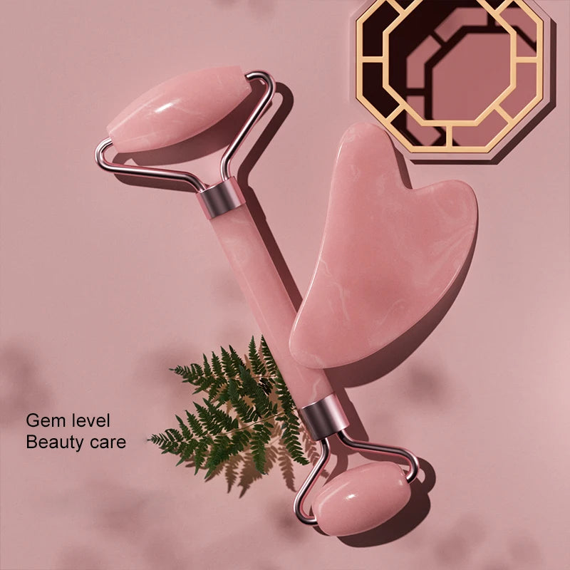Facial massage roller with pink stones and silver metal U-frame, handheld beauty tool