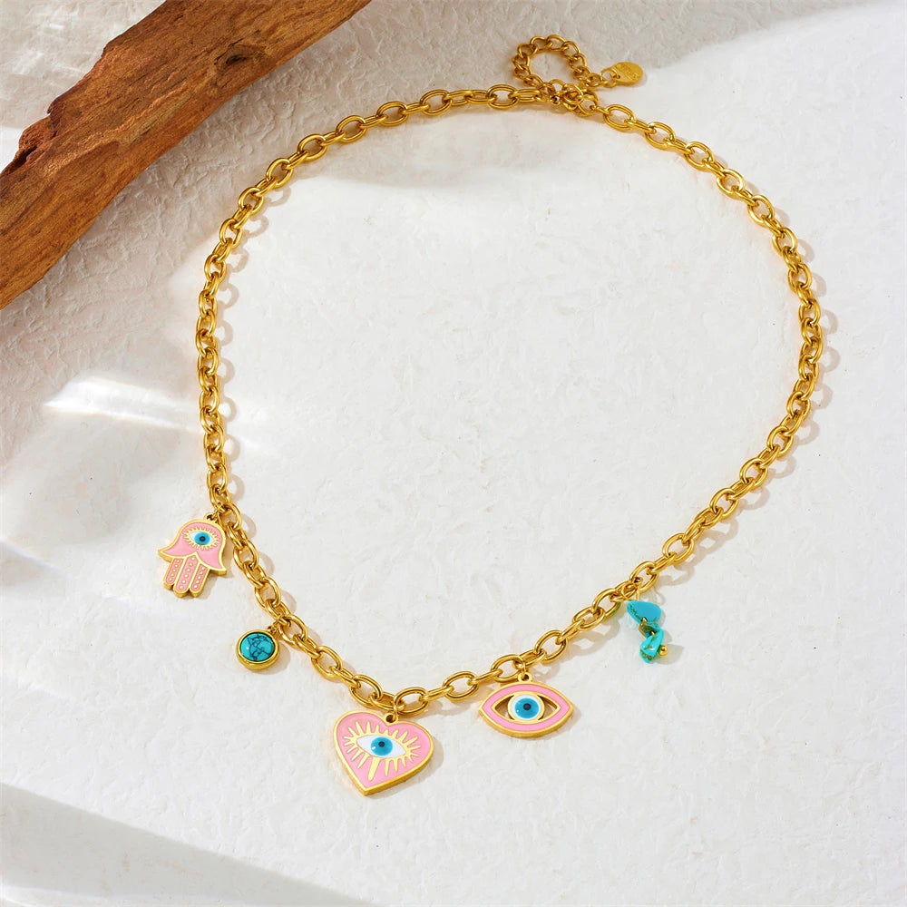Gold-tone evil eye charm bracelet with heart pendant, hamsa hand, and turquoise beads