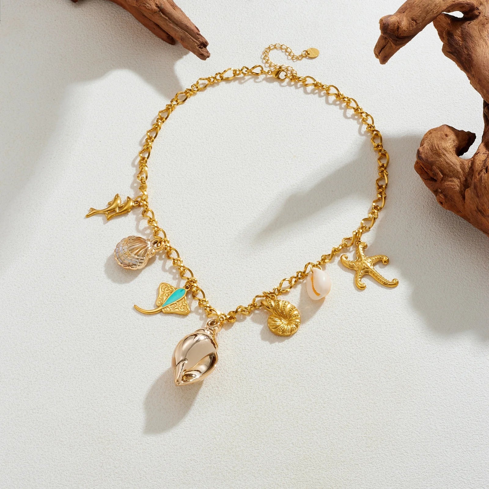 Gold-tone multi-charm ocean necklace with starfish, seashell pendants, and seahorse charm