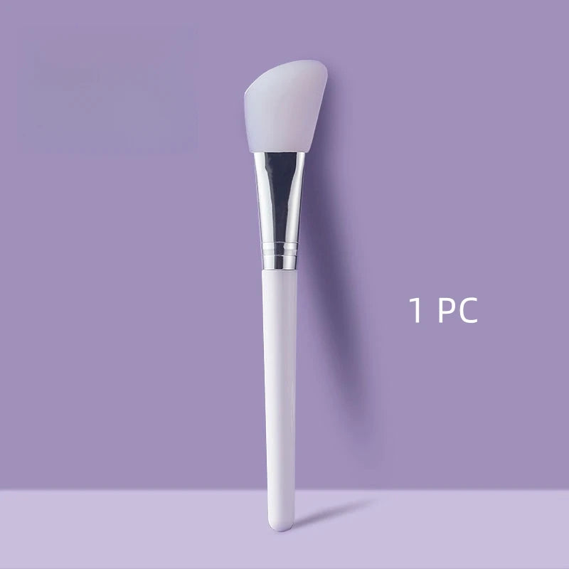 Face mask brush with domed white silicone head, chrome collar, white handle