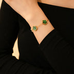 Gold flower bracelet with green enamel clover charms on wrist