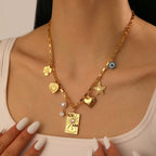 Gold-tone charm necklace with heart, star, square pendant, pearl and zircon details