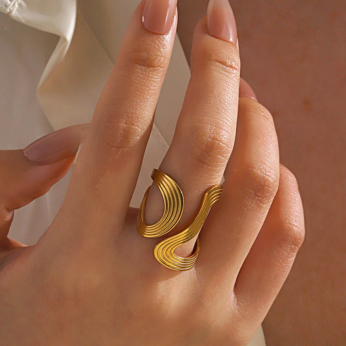Gold-plated open stacking geometric ring set on hand, close-up