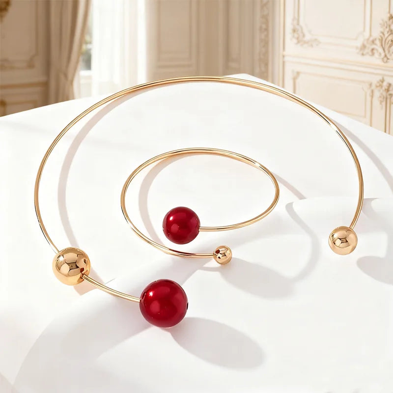Gold-tone pearl collar necklace and bracelet set with red beads and round clasp ends