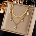 Gold-tone double-layer snake chain necklace with blue evil-eye and round zircon accents