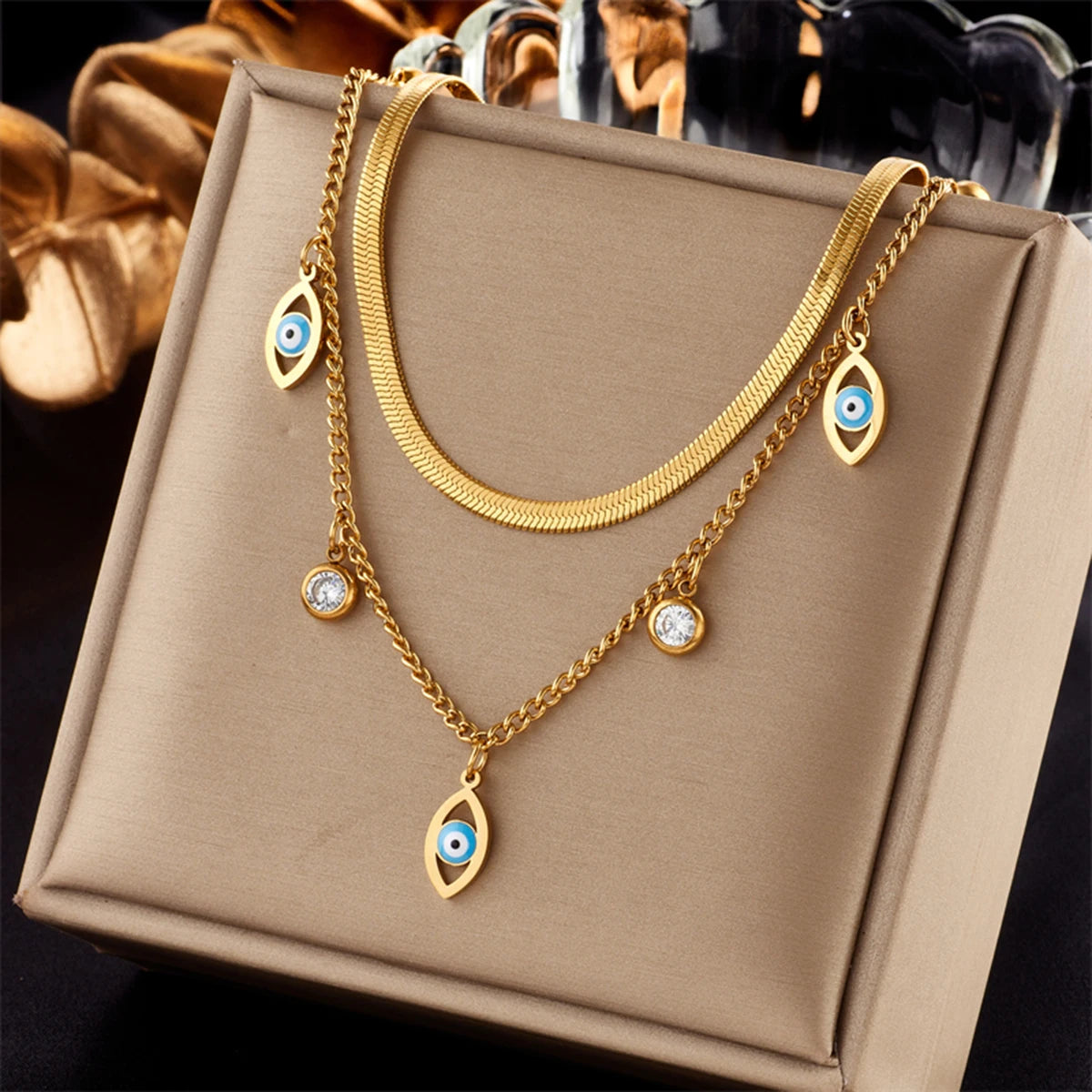 Gold-tone double-layer snake chain necklace with blue evil-eye and round zircon accents