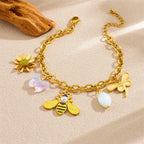 Gold-tone charm bracelet with sun flower, bee, pearl, and white bead drops