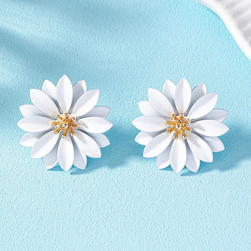 White enamel flower stud earrings with gold-tone center and small crystal details.