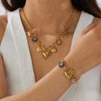 Gold-tone multi-pendant heart, flower, and bow necklace with blue accents on a chain