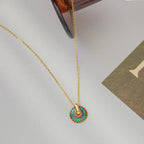 Gold-tone chain necklace with round painted flower pendant and loop bail