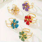 Set of flower cuff bangle bracelets: gold-tone bands with blue, red, green, and white flowers.