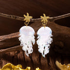 Pair of gold starfish jellyfish earrings with clear translucent jelly charms.