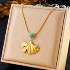 Gold-tone necklace with turquoise cabochon and ginkgo leaf fan pendant in gift box