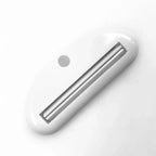 White toothpaste tube squeezer dispenser with slotted metal insert and hanging hole
