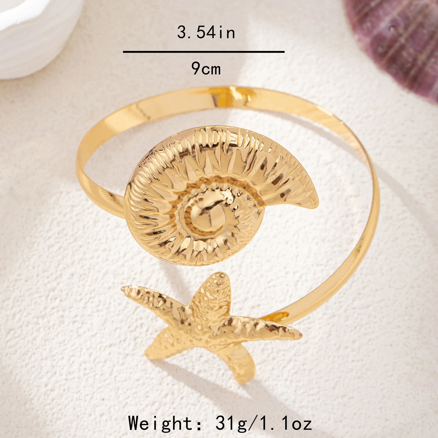 Gold shell disk and starfish arm cuff with ridged disk and raised starfish detail