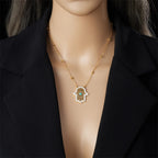 Gold-tone necklace with turquoise hamsa pendant and link chain, worn on model