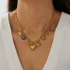 Gold-tone multi-pendant necklace with heart, bow, and tassel charms plus blue flower details
