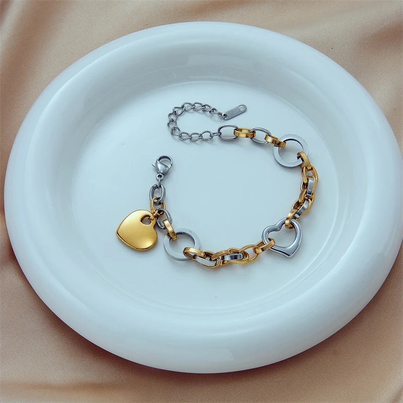 Gold and silver charm bracelet with heart pendants and round clasp