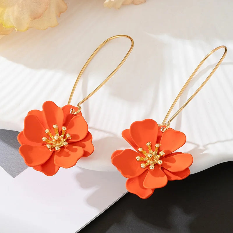 Floral stud earrings with layered orange flower petals and gold-tone hooks