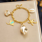 Gold-tone enamel ocean charm bracelet with starfish, dolphins and shell conch charms