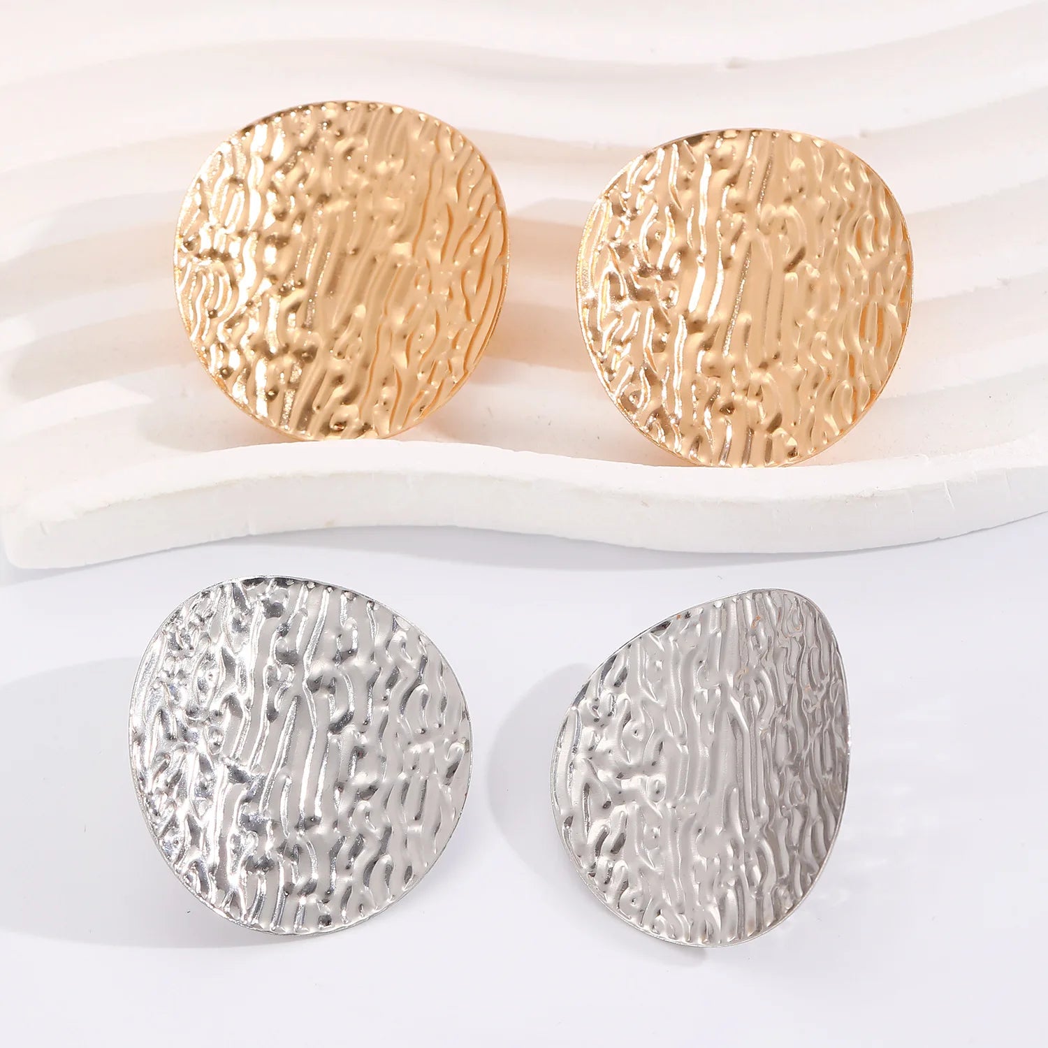 Textured disc stud earrings in gold and silver, round hammered look