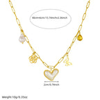 Gold-tone chain necklace with heart pendant, butterfly charm, flower motifs, pearl drop