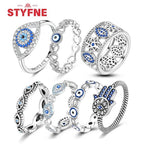 Sterling silver evil eye ring with blue circular center and crystal halo bezel