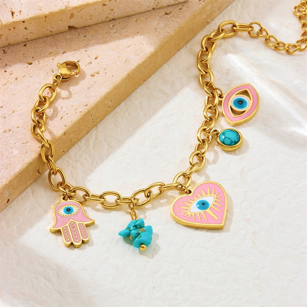 Gold-tone charm bracelet with evil eye heart, hamsa hand, and turquoise flower charm